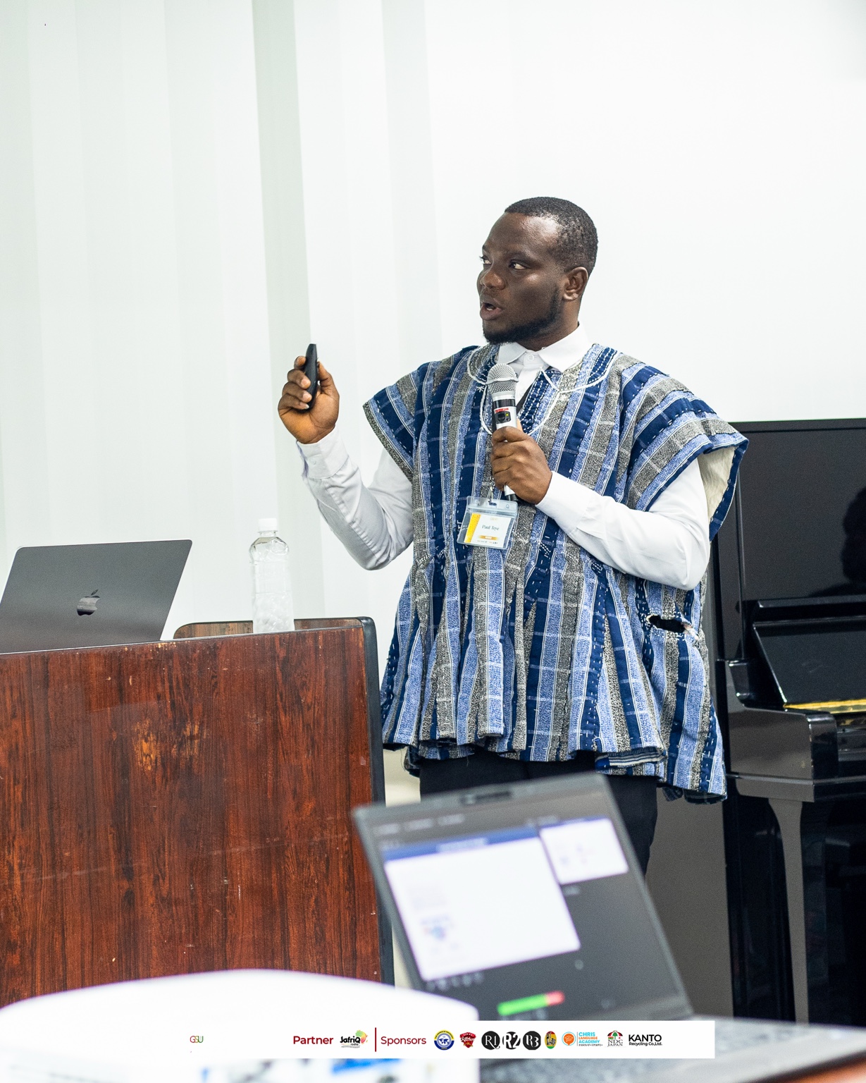 Paul Teye presenting research in traditional Ghanaian attire